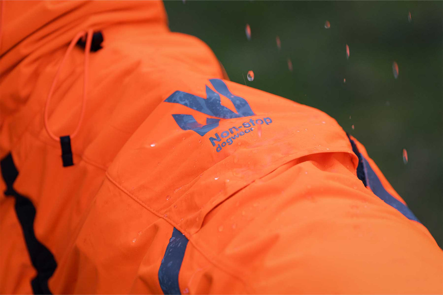 Impermeable naranja Non-stop dogwear bajo la lluvia