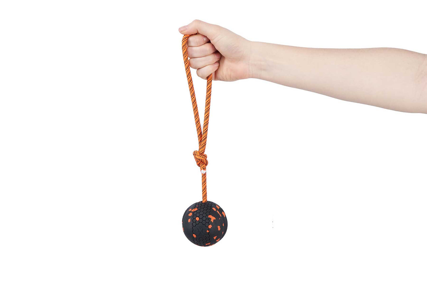 Brazo sujetando pelota negra con cuerda naranja para perros Non-stop dogwear