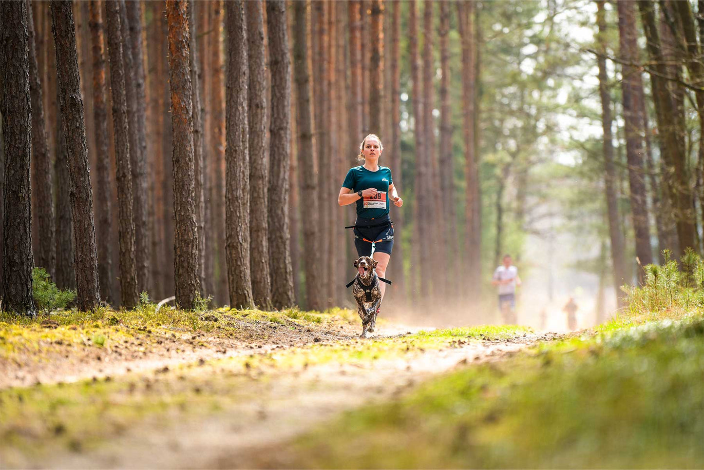 Camiseta CaniX Tech tee teal Women's canicross con 1 perro en el bosque
