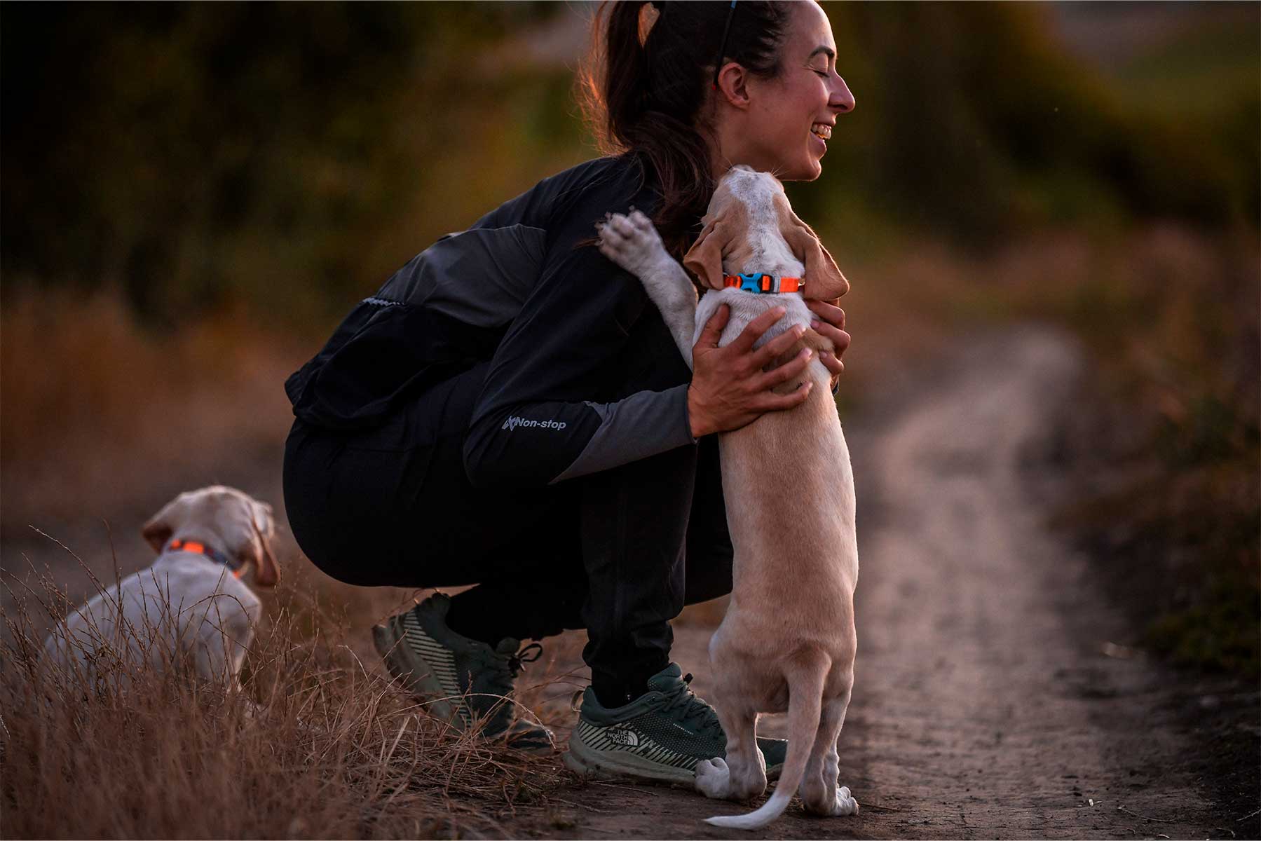 Chica con un cachorro con la chaqueta 
Non-stop dogwear Canix warm up jacket