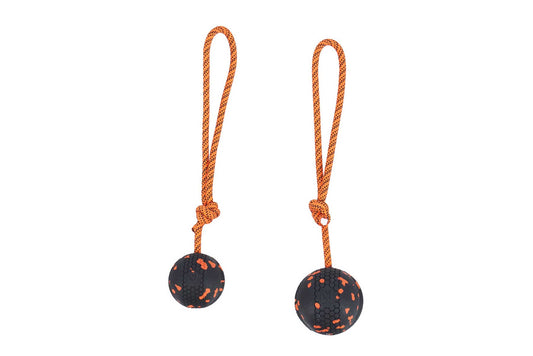 Pelotas de color negro con cuerda naranja y nudo para adiestramiento.