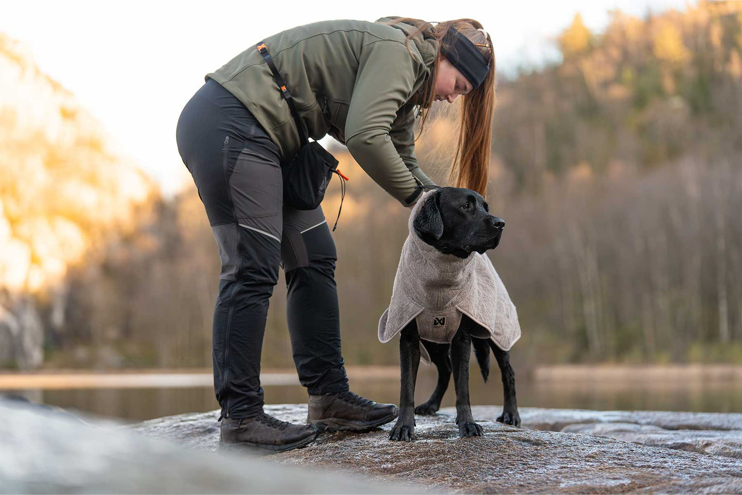 Chica poniendo el Non-stop dogwear drying coat a su perro