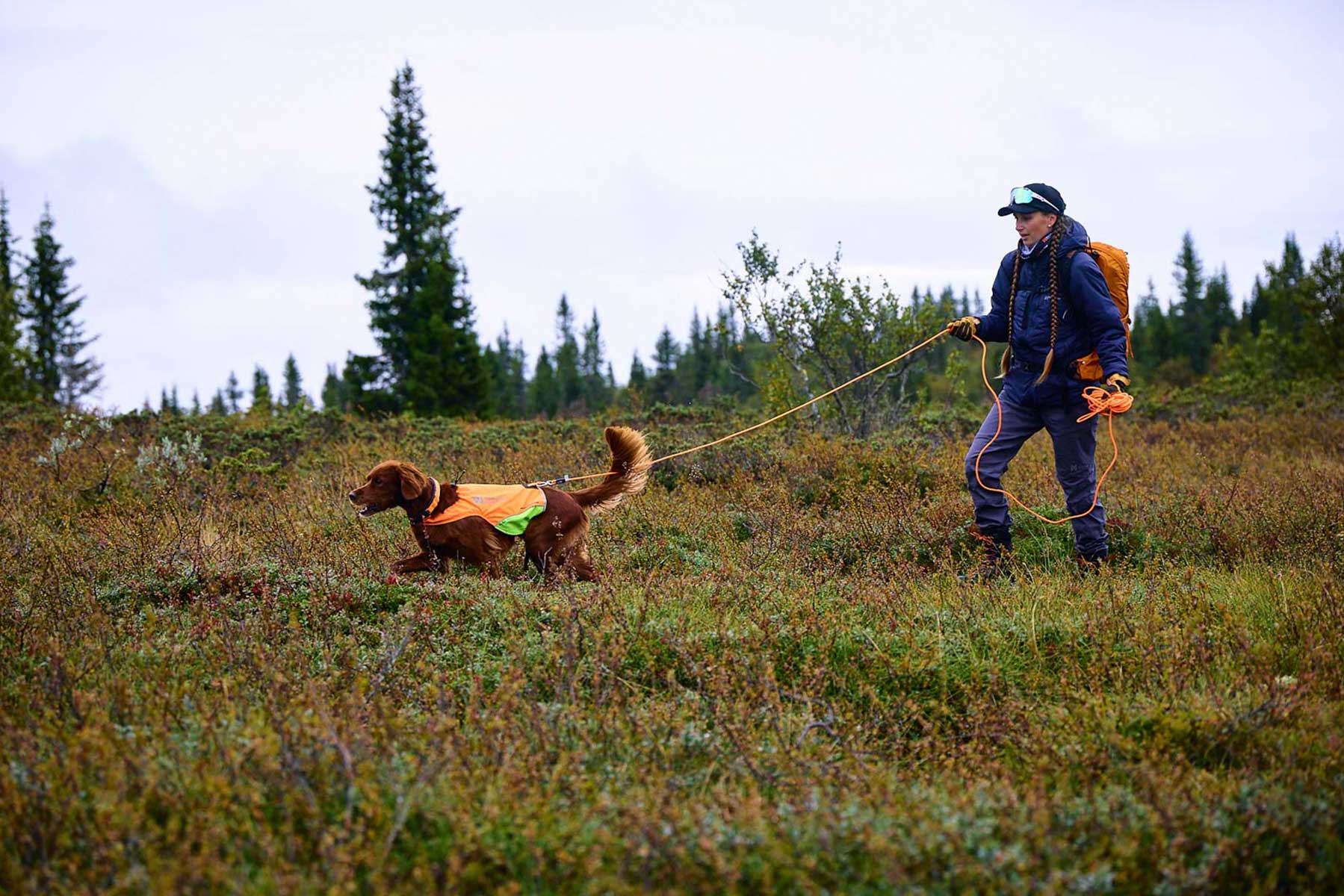 Chica usando en la montaña una Correa larga Protector round long line Non-stop dogwear