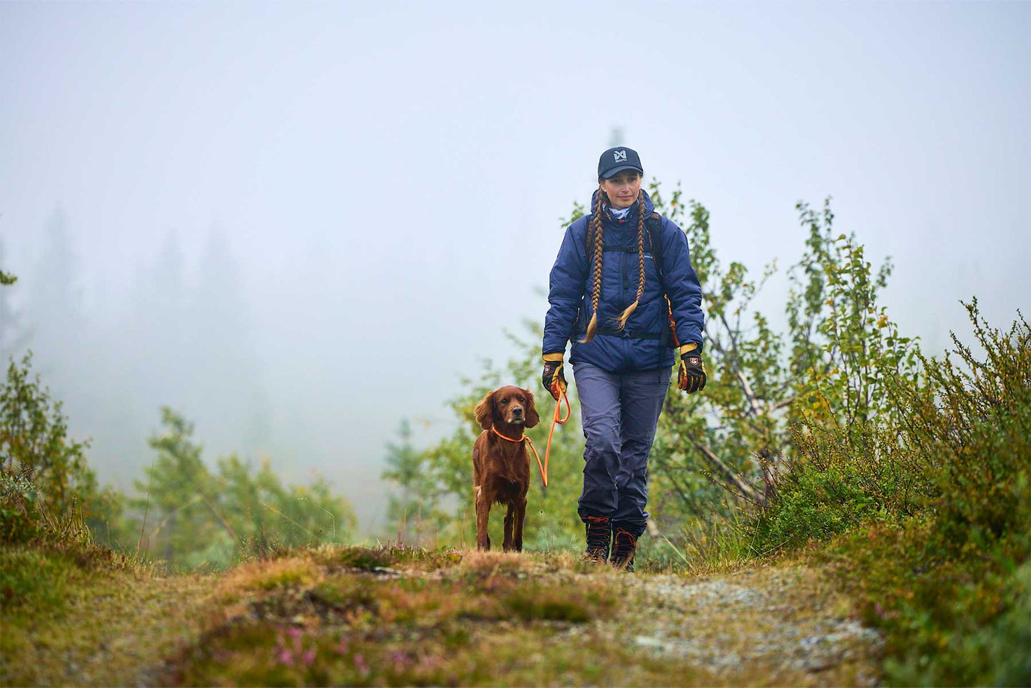 chica en la montaña con su perro de color marrón y la Non-stop-dogwear retriever leash naranja