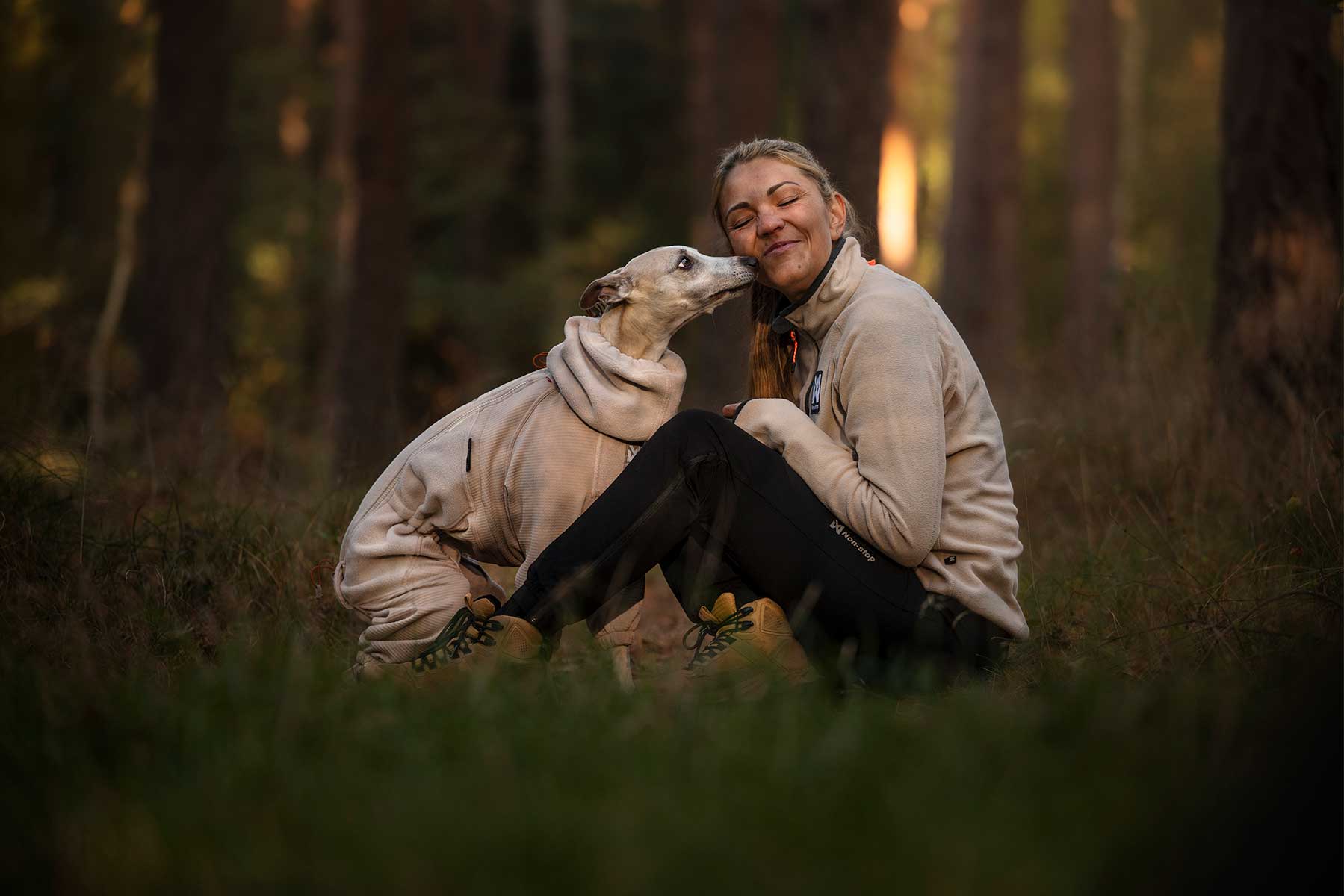 Chica disfrutando del cariño que le da su perro, ambas van conjuntados con polares de Non-stop dogwear